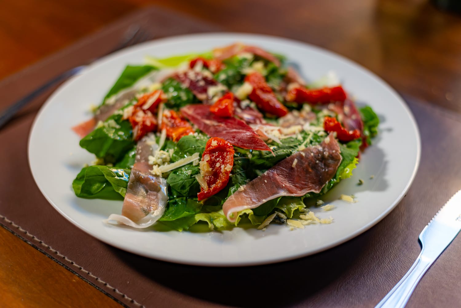 Salada com presunto cru, tomates secos e queijo servida no bistrô