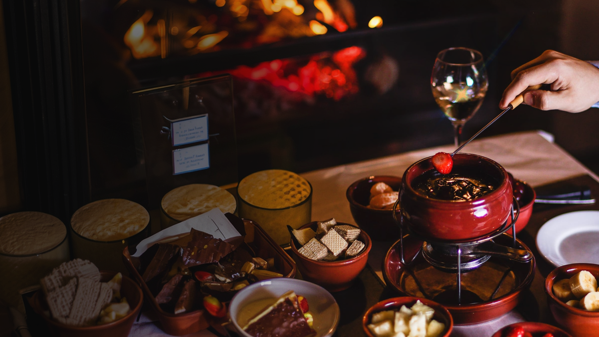 Fondue de chocolate servido à mesa diante da lareira acesa